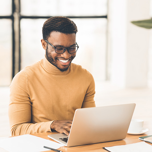 Headshot of handsome black guy using laptop