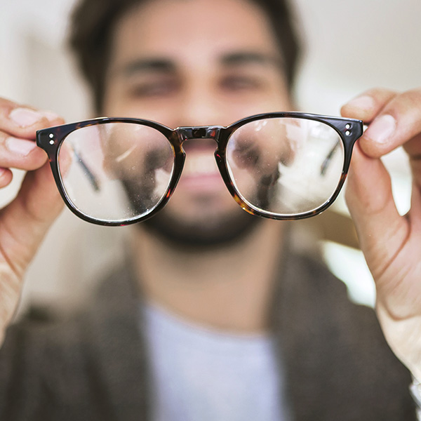 Man choosing wearing glasses in optical store